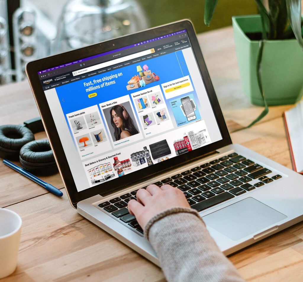 Person on laptop with the Amazon homepage displayed on the screen