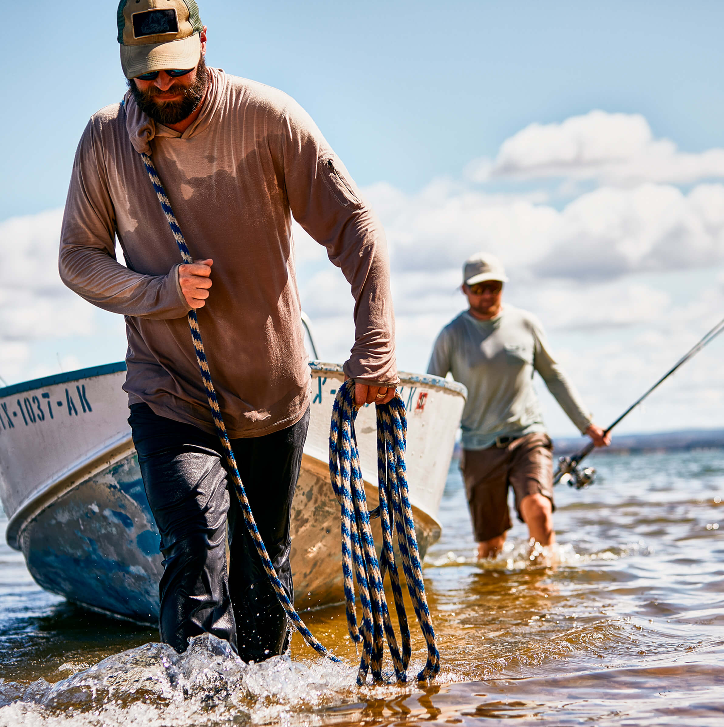 2 men pulling a boat back to shore