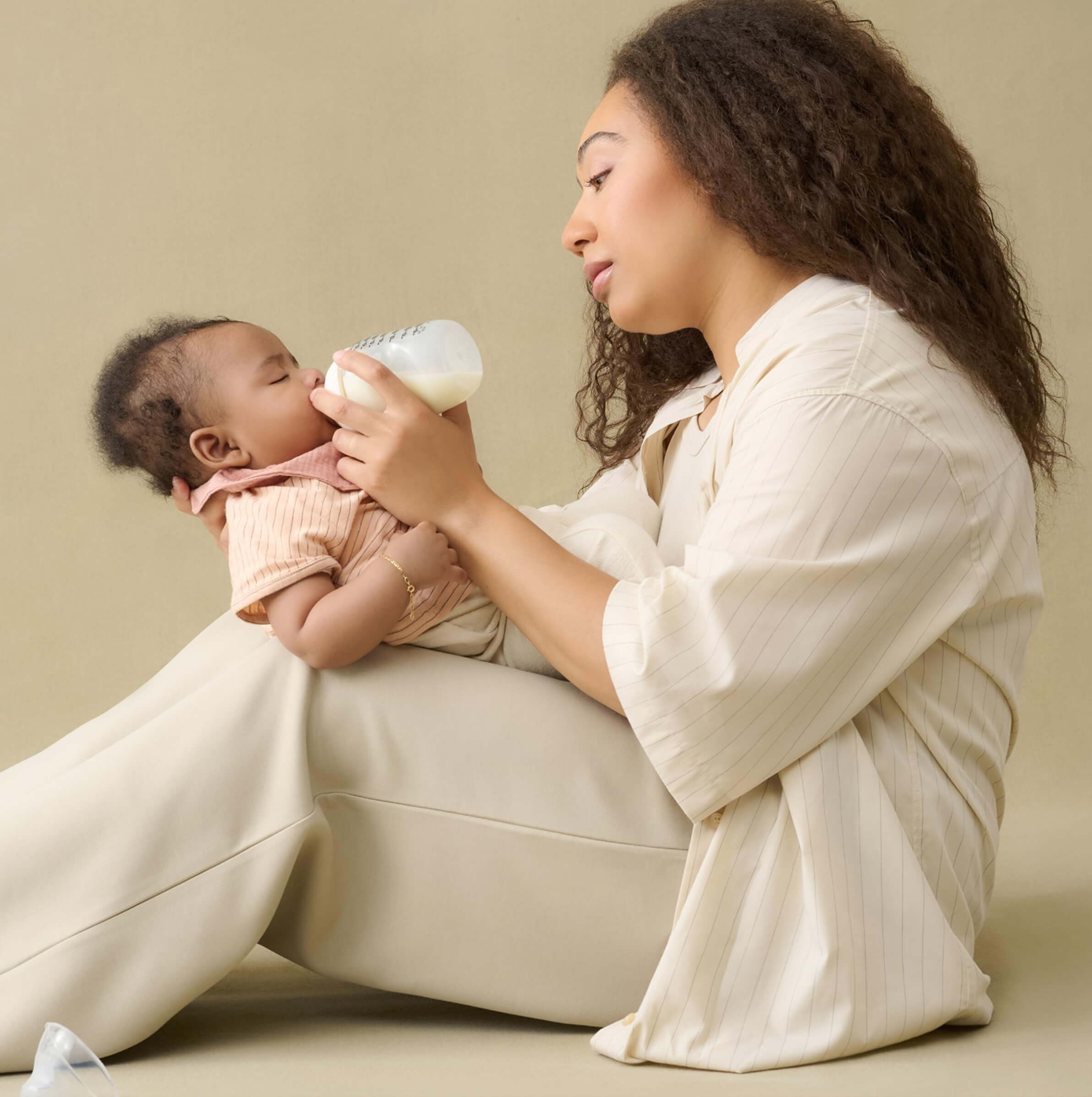 Woman holding a baby and bottle feeding them