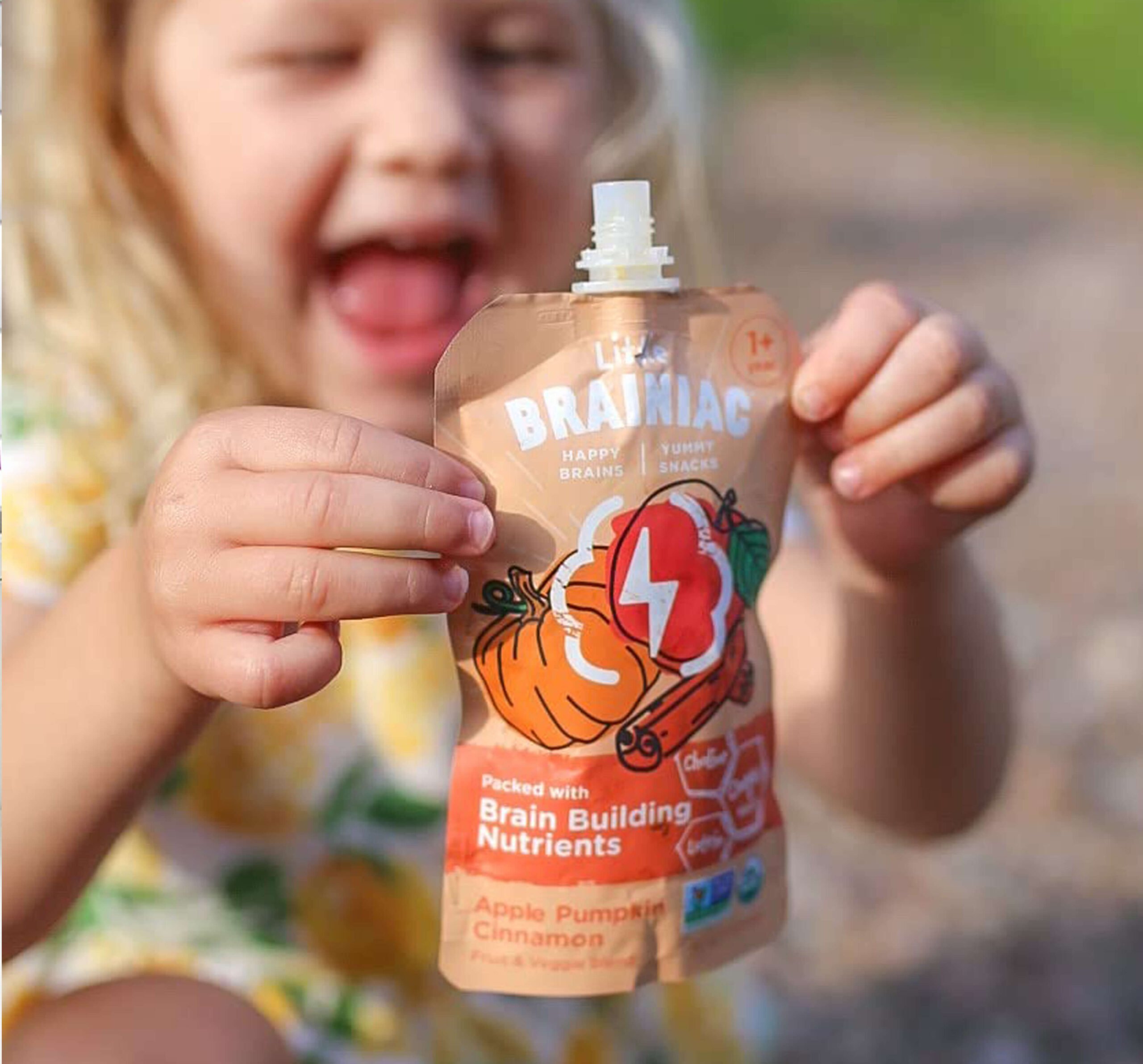 Toddler holding a Little Brainiacs food pouch
